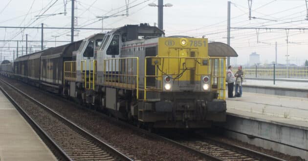 SNCB goods train passing Antwerpen Luchtbal station (CC BY NC SA) MEDIARAIL.BE-Flickr. Cropped image.