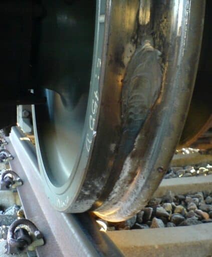 Rueda de un tren en la que se observa la pestaña a la derecha y una banda de rodadura deteriorada. (CC BY SA) TYDAL - Wikimedia Commons