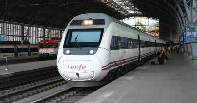 Renfe’s OSP commuter and commercial trains at Bilbao Abando. (CC BY SA) DINING CAR – Wikimedia Commons. Cropped image.